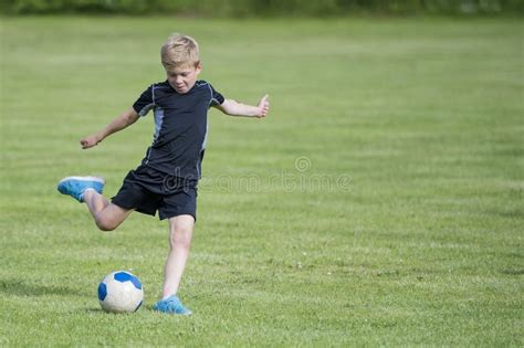 Menino Que Retrocede A Esfera De Futebol Foto De Stock Imagem De