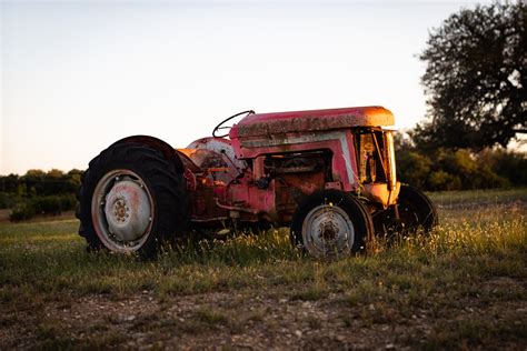 Rusty Tractor on Grass Field During Golden Hour · Free Stock Photo