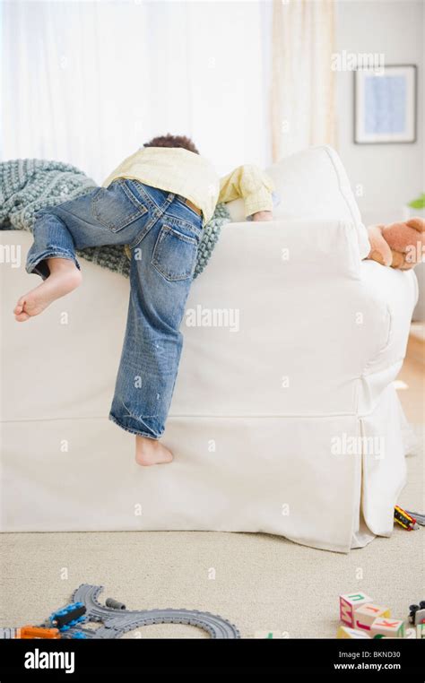 Black Boy Climbing Over Back Of Sofa Stock Photo Alamy