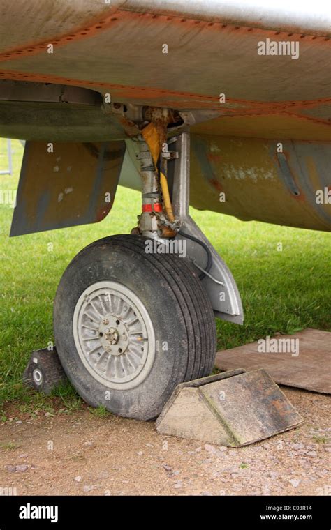 A landing wheel of an airplane with chocks. The plane is stationery ...