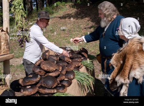 Men In Latvian Folk Costume Buying Local Bread At The Ethnographic Open