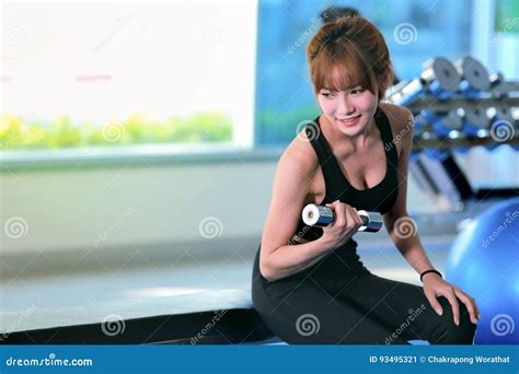 Fitness Woman Doing Biceps Workouts With Dumbbells In A Gym Stock