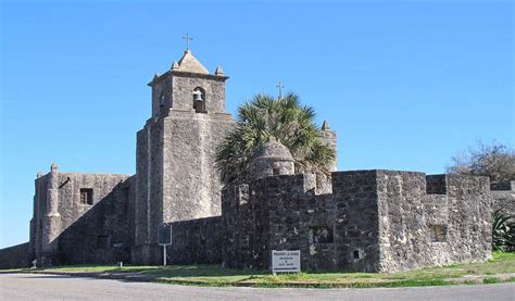 An Old Stone Building With A Palm Tree In Front