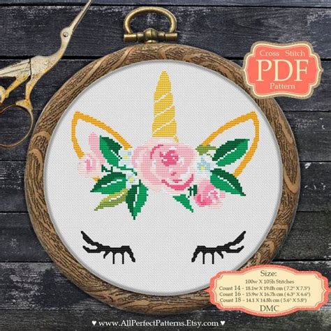 A Cross Stitch Unicorn Face With Flowers On It S Head Is Shown In The Hoop