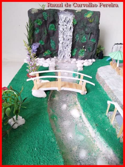 A Miniature Waterfall And Bridge Made Out Of Fake Grass With Flowers On