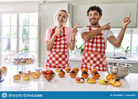 Couple Of Wife And Husband Cooking Pastries At The Kitchen Smiling And Looking At The Camera