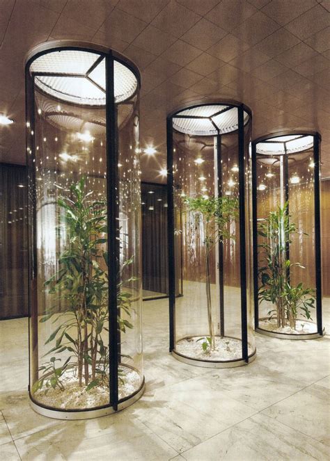 Three Round Glass Cases With Plants In Them