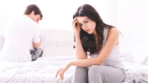 Couple Sitting On Bed With Sad Expressions Stock Image Image Of