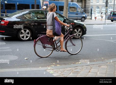 A Mature Woman Riding A New Looking Purple Unisex Frame Bike Handbag And Purple Tote Bag