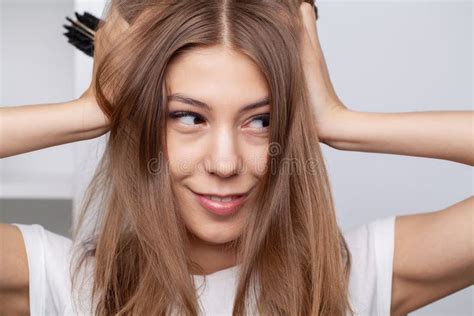 Mujer Sonriente Atractiva Cepillando Su Largo Cabello Recto Imagen De