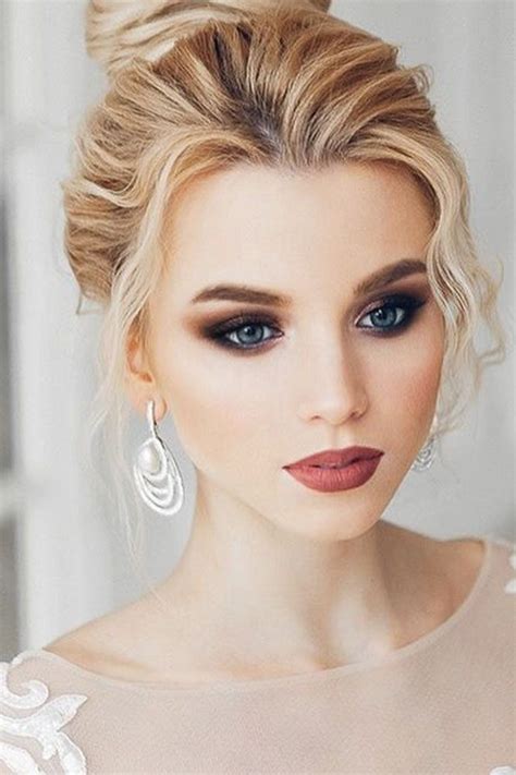 A Woman With Blonde Hair And Blue Eyes Wearing Wedding Makeup Is