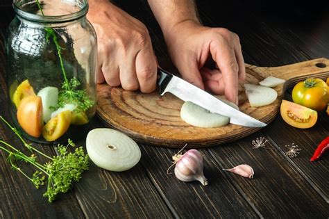 Preparação de salada de legumes enlatada as mãos do chef cortam a