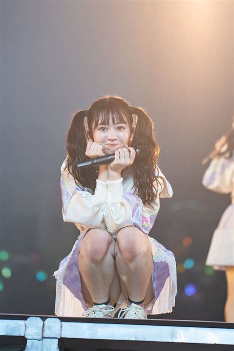 A Woman Sitting On Top Of A Stage While Holding A Microphone