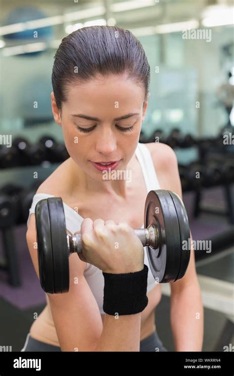 Fit Smiling Brunette Lifting Heavy Black Dumbbell At The Gym Stock