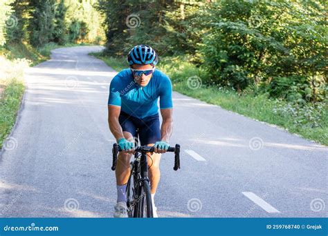 Racing Cyclist Riding Uphill On An Open Road Cycling Route Stock Photo