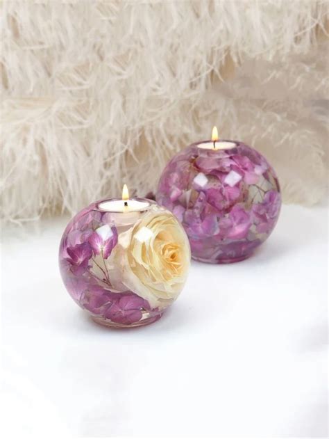 Two Purple And White Glass Candles Sitting Next To Each Other