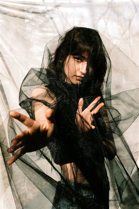 A Woman Wearing A Black Dress And Holding Her Hands Out Photo Free