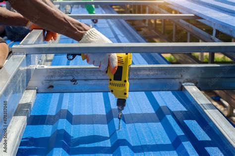 Construction worker install new roof,Roofing tools,Electric drill used on new roofs with Metal ...