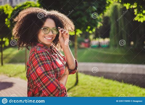 Portrait Of Attractive Cheerful Carefree Girl Wearing Checked Shirt Bushy Hair Touching Specs