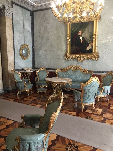 An Ornately Decorated Room With Blue Chairs And Gold Trimmings On The Walls