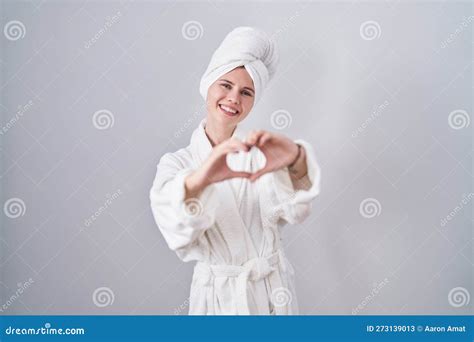 Blonde Caucasienne Femme En Peignoir Sourire Amoureux Faire Forme De Symbole Du Coeur Avec Les