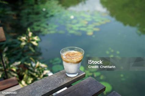 Segelas Kopi Latte Di Atas Meja Kayu Dengan Pemandangan Danau Teratai