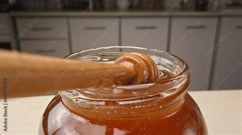 Golden Organic Honey In A Jar With A Wooden Stick Closeup Footage Of