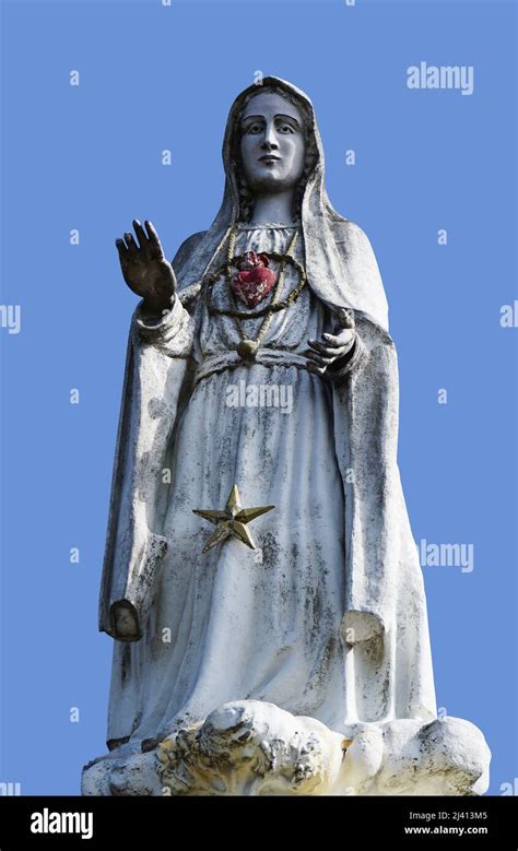 Statue of Virgin Mary isolated on blue background Stock Photo - Alamy