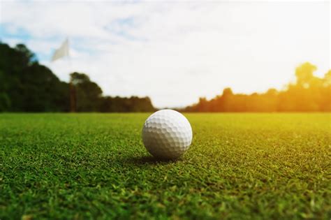 Premium Photo Golf Ball On Green Grass With Hole And Sunlight