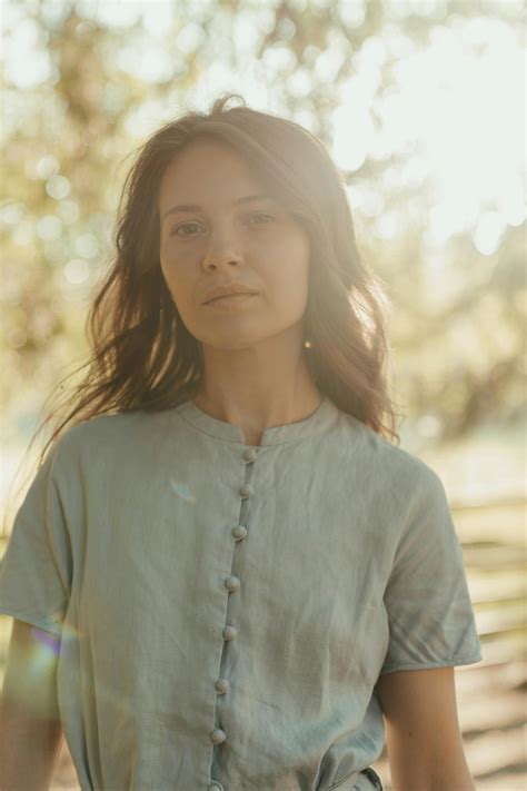 Woman In White Long Sleeve Shirt Sitting On Green Grass Field · Free