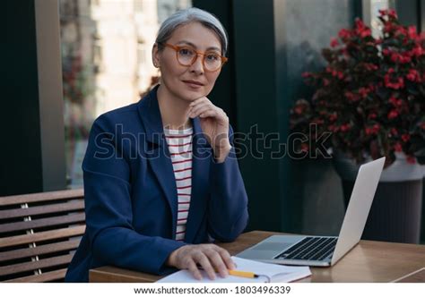 Pensive Mature Business Woman Looking Camera Stock Photo 1803496339