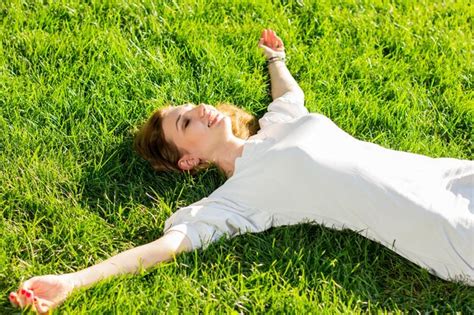 Hermosa mujer sonriente tumbada en un césped al aire libre ella es