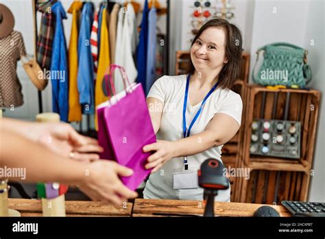 Brunette Woman With Down Syndrome Working As Shop Assistant Holding