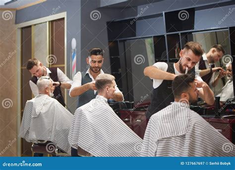 Three Professional Barbers Trimming Cutting And Styling Male Clients