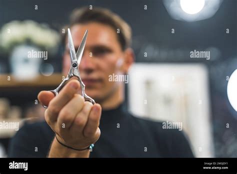 Blurred Hairdresser Man Holding Scissors In Front Of His Face High