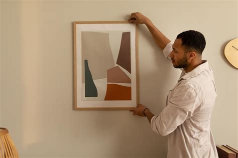 Joven Negro Colgando Pintura Poniendo Marco De Imagen En La Pared