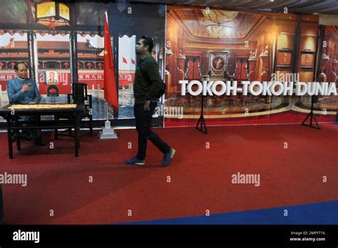 A Visitor Walks Past A Sign That Reads Famous Figures Of The World