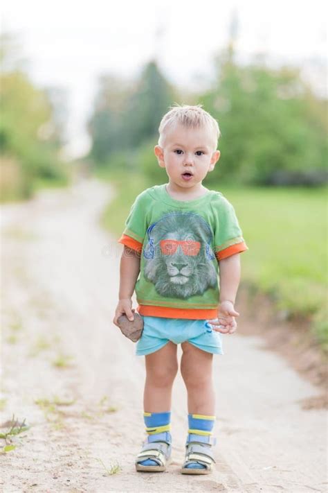 A Surprised Boy with an Open Mouth and a Stone in His Hands Stock Photo ...