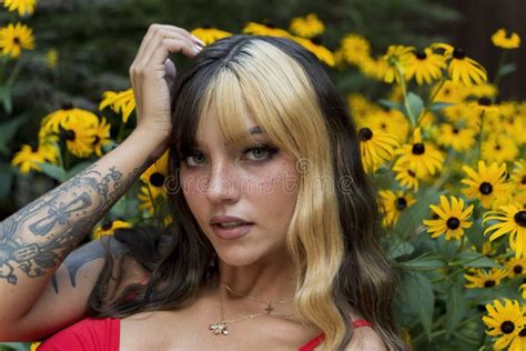 A Lovely Brunette Model Poses In A Field Of Yellow Flowers While Enjoying The Summer Weather