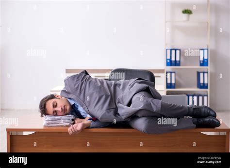 Young employee sleeping in the office Stock Photo - Alamy