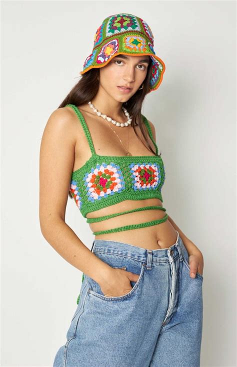 A Woman Wearing A Green Crochet Crop Top And Blue Jeans With Her Hands