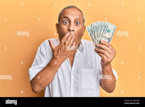 Handsome Mature Man Holding 20 Dollars Banknotes Covering Mouth With
