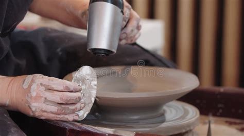 A Woman Eating The Clay Plate On The Pottery Wheel Using A Hairdryer
