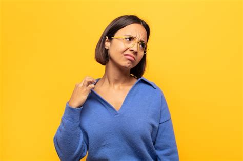 Joven latina sintiéndose estresada ansiosa cansada y frustrada tirando del cuello de la