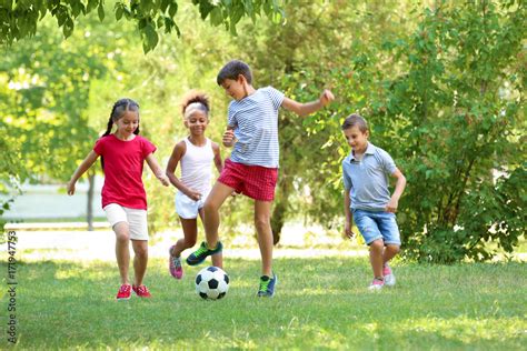 Cute children playing football in park Stock Photo | Adobe Stock