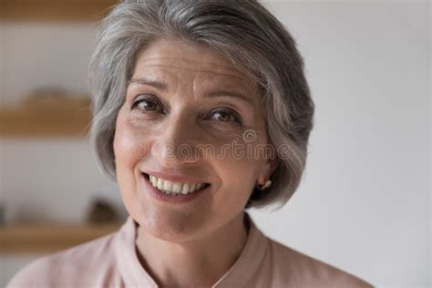 Facial Portrait Of Happy Mature Retired Woman Looking At Camera Stock