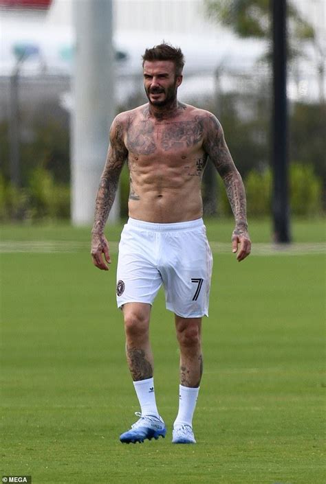 A Shirtless Man Standing On Top Of A Soccer Field