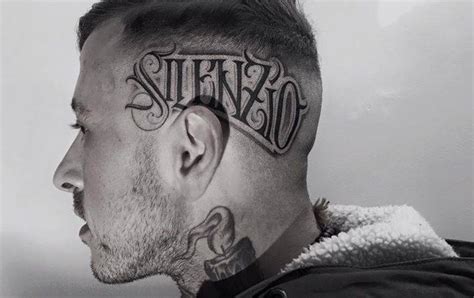 "Silenzio" tattoo on the left side of the head.