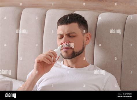 Ill Man Using Nasal Spray In Bed At Home Stock Photo Alamy