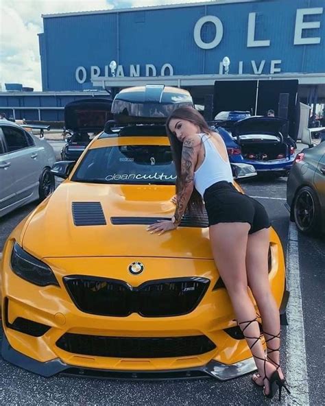 A Woman Leaning On The Hood Of A Yellow Car